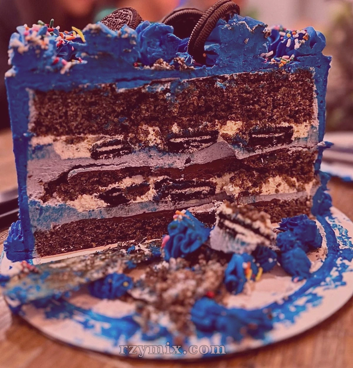 cookies n' creme cake filled with cookie sandwiches and whipped cream, decorated with lemon buttercream