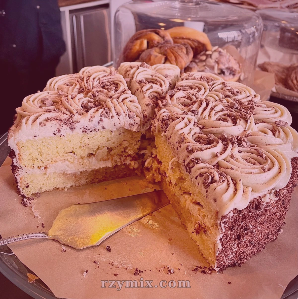 vanilla bean cake soaked with cherry syrup, filled and decorated with sage brown butter cream cheese frosting, coated with chocolate crumbs