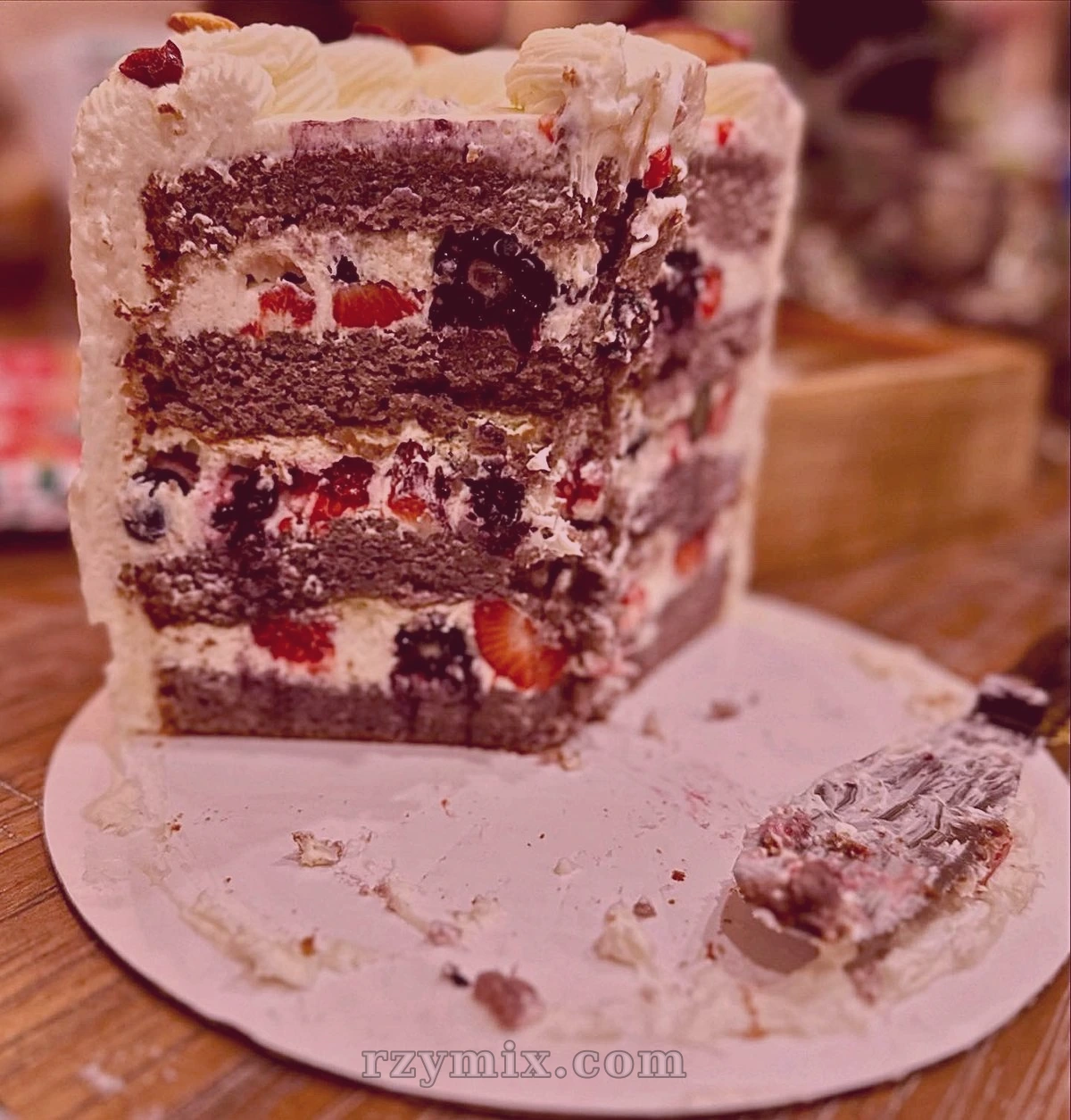 ube cake soaked with berry syrup, filled with fresh mixed berries, and decorated with vanilla chantilly frosting